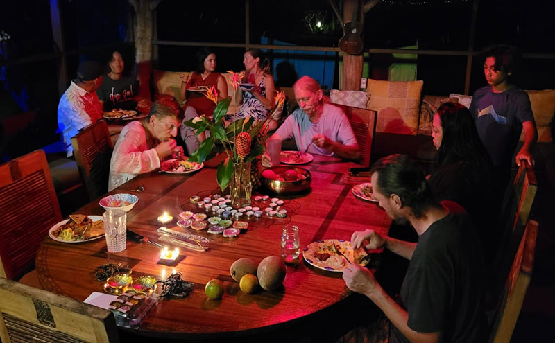 Guests enjoying the food offering in the outdoor dining room of the Coco Wasi retreat center in sunny Kapoho of Pahoa, Hawaii